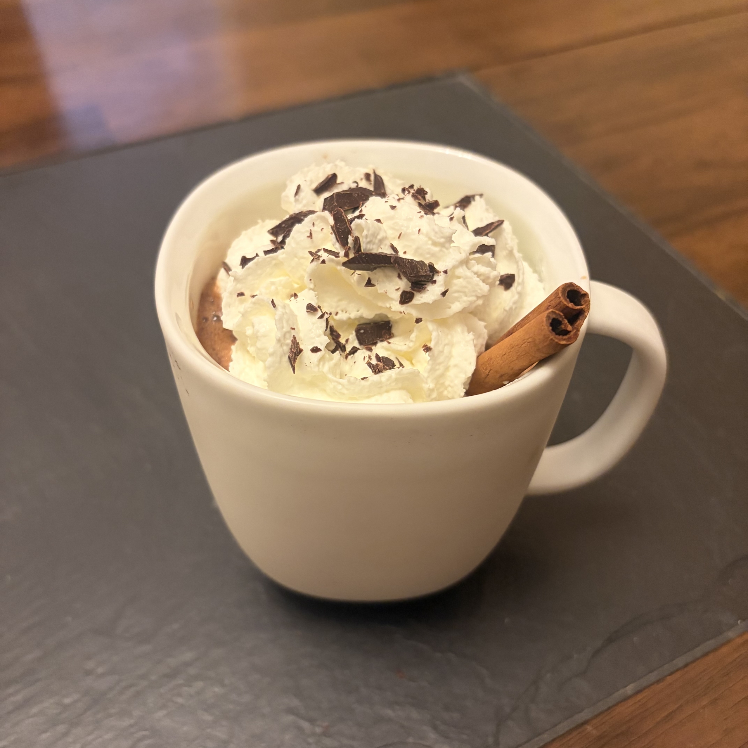 Mexican Hot Chocolate with whipped cream and chocolate sprinkles in a mug.